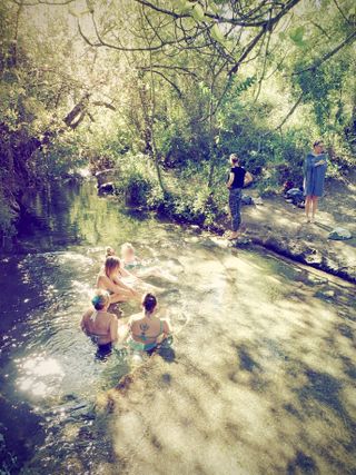 Sample photograph taken with the OM System Tough TG-7, of a group of women wild swimming in a river with overhanging branches