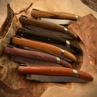 closeup of six pocketknives, each of which has a wood handle