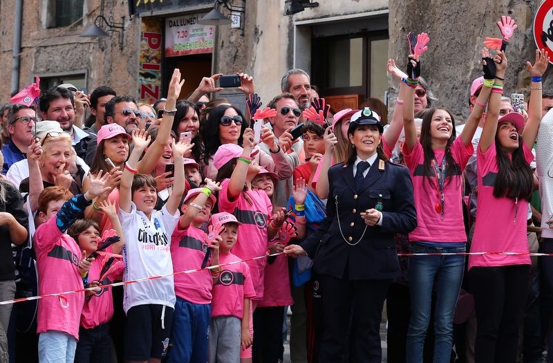 A policewoman keeps the fans from encroaching onto the road and causing a crash
