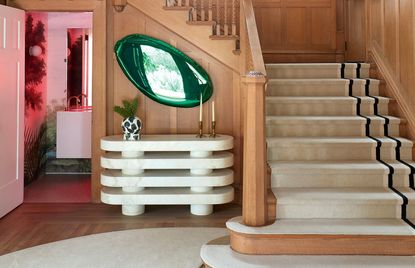 large entryway with wooden stair rail and white console table