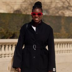 nikki ogunnaike wearing a black blazer and white pants