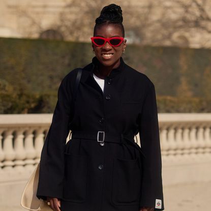 nikki ogunnaike wearing a black blazer and white pants 
