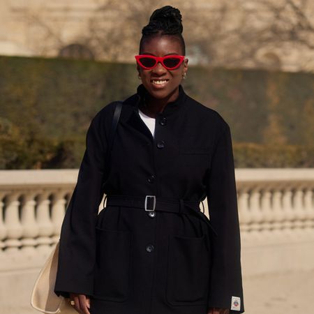 nikki ogunnaike wearing a black blazer and white pants 