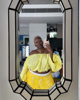 flex wears pale yellow off the shoulder top while taking a mirror selfie