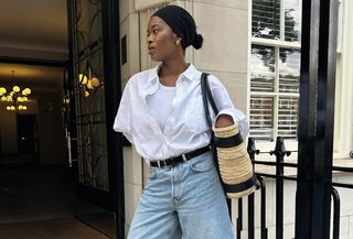 An influencer wearing relaxed denim shorts and a white shirt.