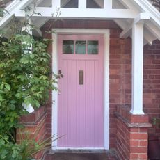 pink front door in white painted porch