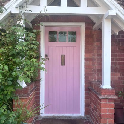 pink front door in white painted porch