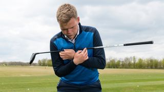 Tour coach Liam James demonstrating how to set up properly to hit a fairway wood