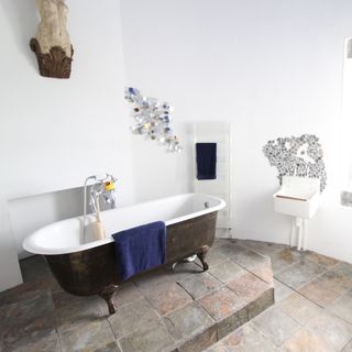 bathroom with bathtub and slate tiled flooring