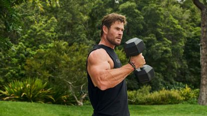 Chris Hemsworth doing bicep curls with a pair of dumbbells