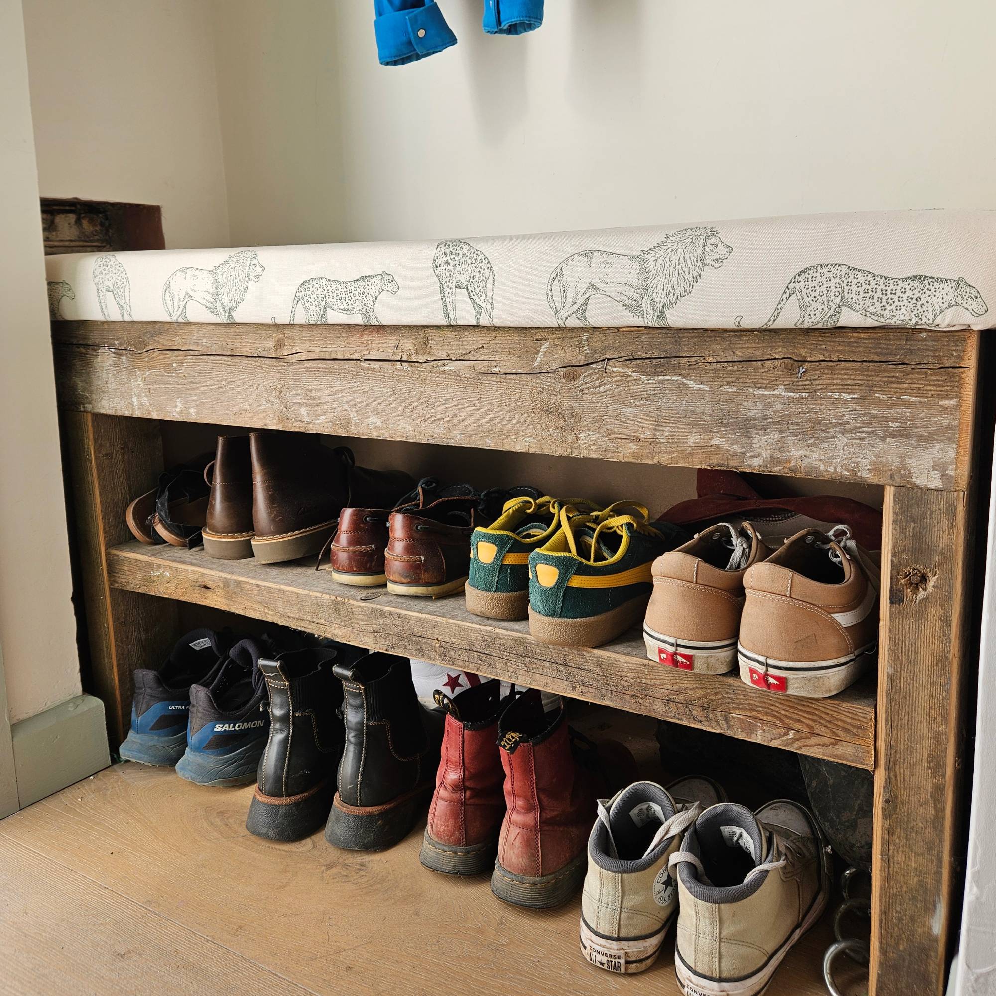wooden storage bench in hallway with animal print cushion