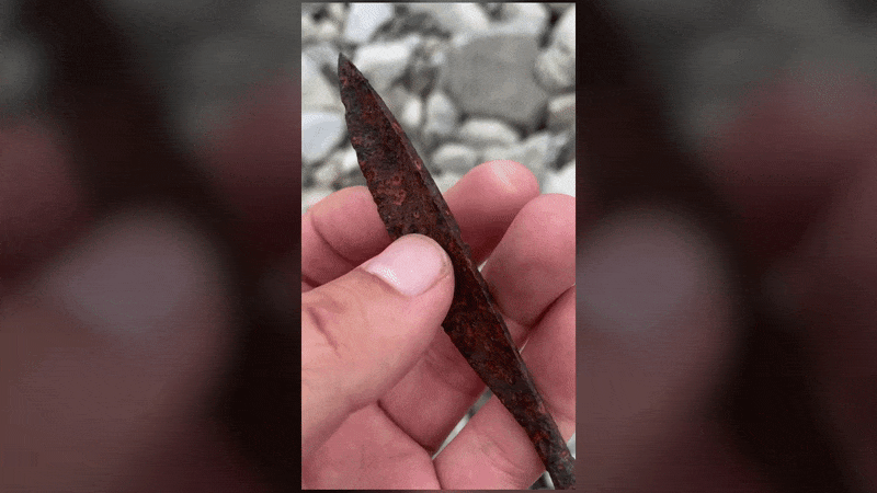Gif of a person holding the arrowhead found in Norway.