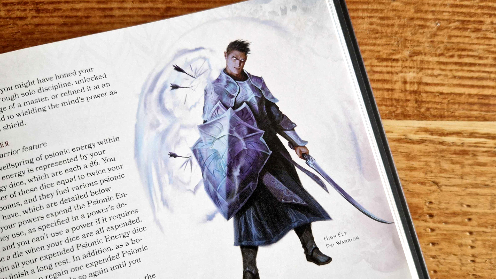 Dungeons & Dragons book on a wooden table, open on a page with a High-Elf Psi Warrior illustration