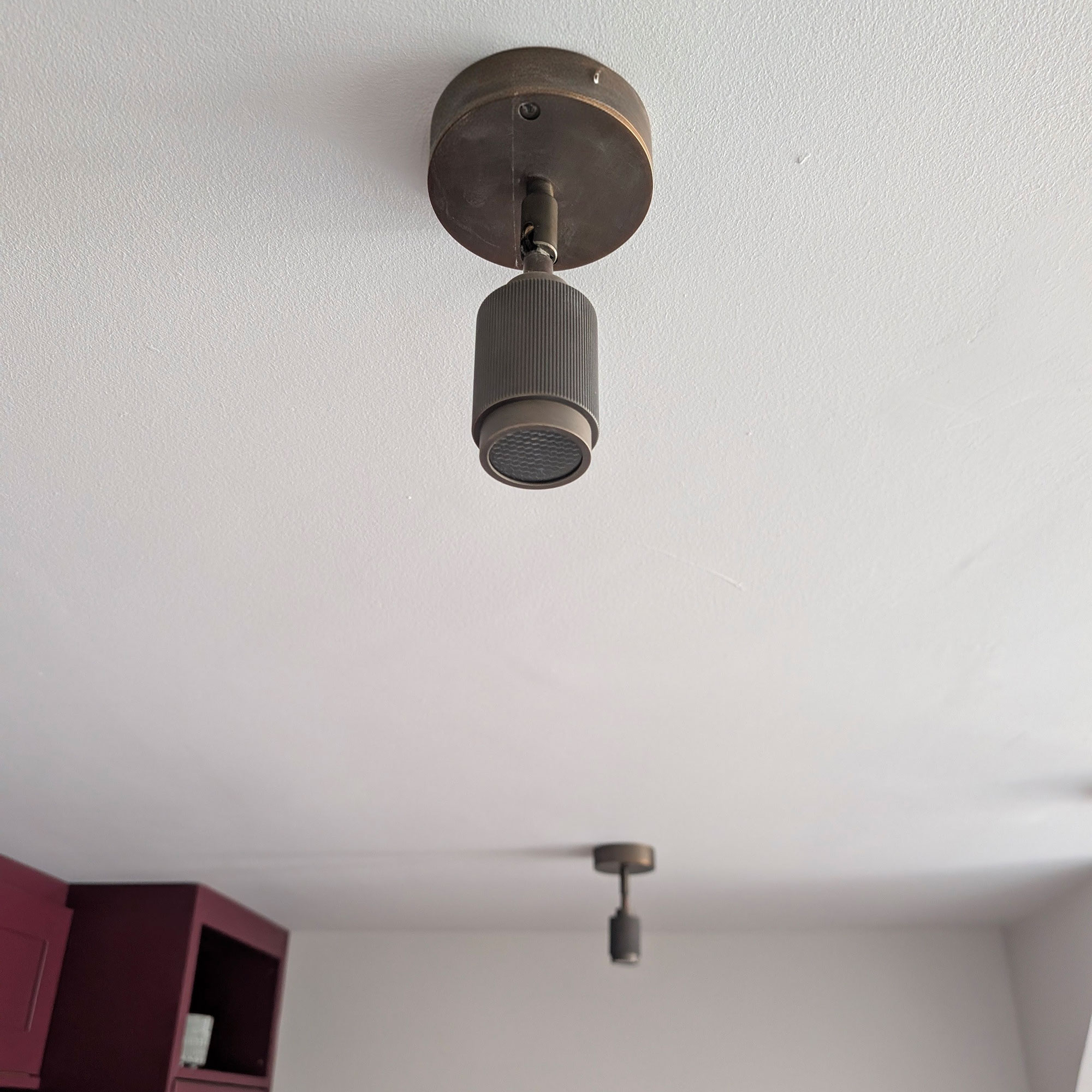 Brass downlighter spotlights in white ceiling