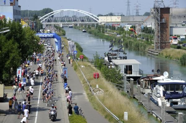 The peloton speeds through the start/finish along the canal