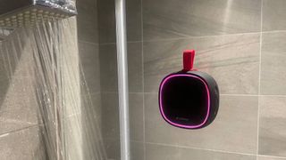 Lenrue F9 Bluetooth speaker attached to a glass shower door