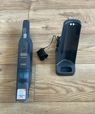 Black+Decker 12V MAX Dustbuster parts on wooden floor