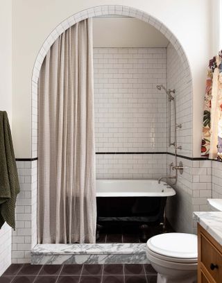 A bathroom with curtains dividing the bathtub