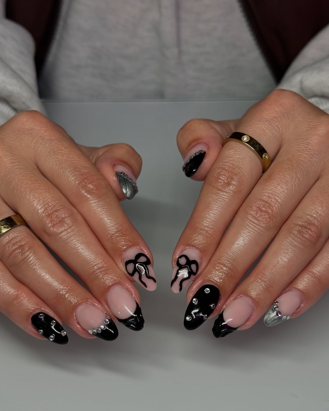 a person wearing a black manicure with mixed designs