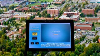 An Extron TouchLink Pro super imposed in front of the campus at Middle Tennessee State.