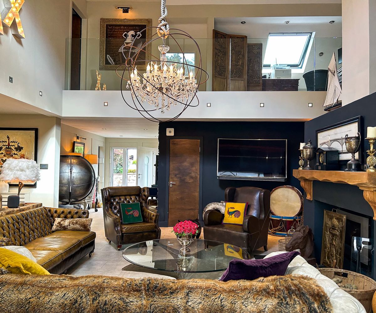 A living room with a chandelier and a wooden fireplace