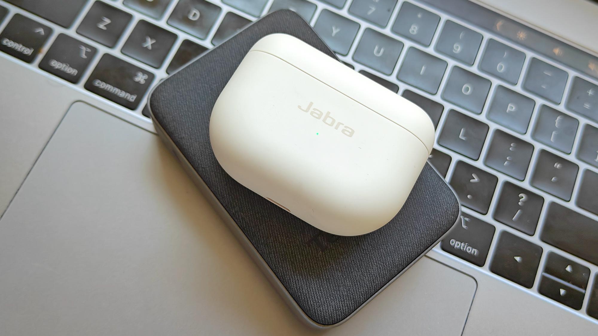 Jabra Elite 10 en estuche de carga en la parte superior del teclado