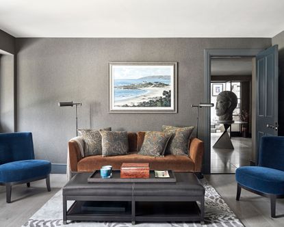 Grey living room with brown sofa and blue chairs