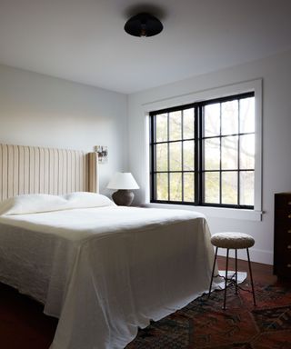 modern cottage transitional bedroomwith an antique rug and modern bed linens and decor