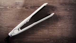 A pair of straighteners sitting on a wooden surface