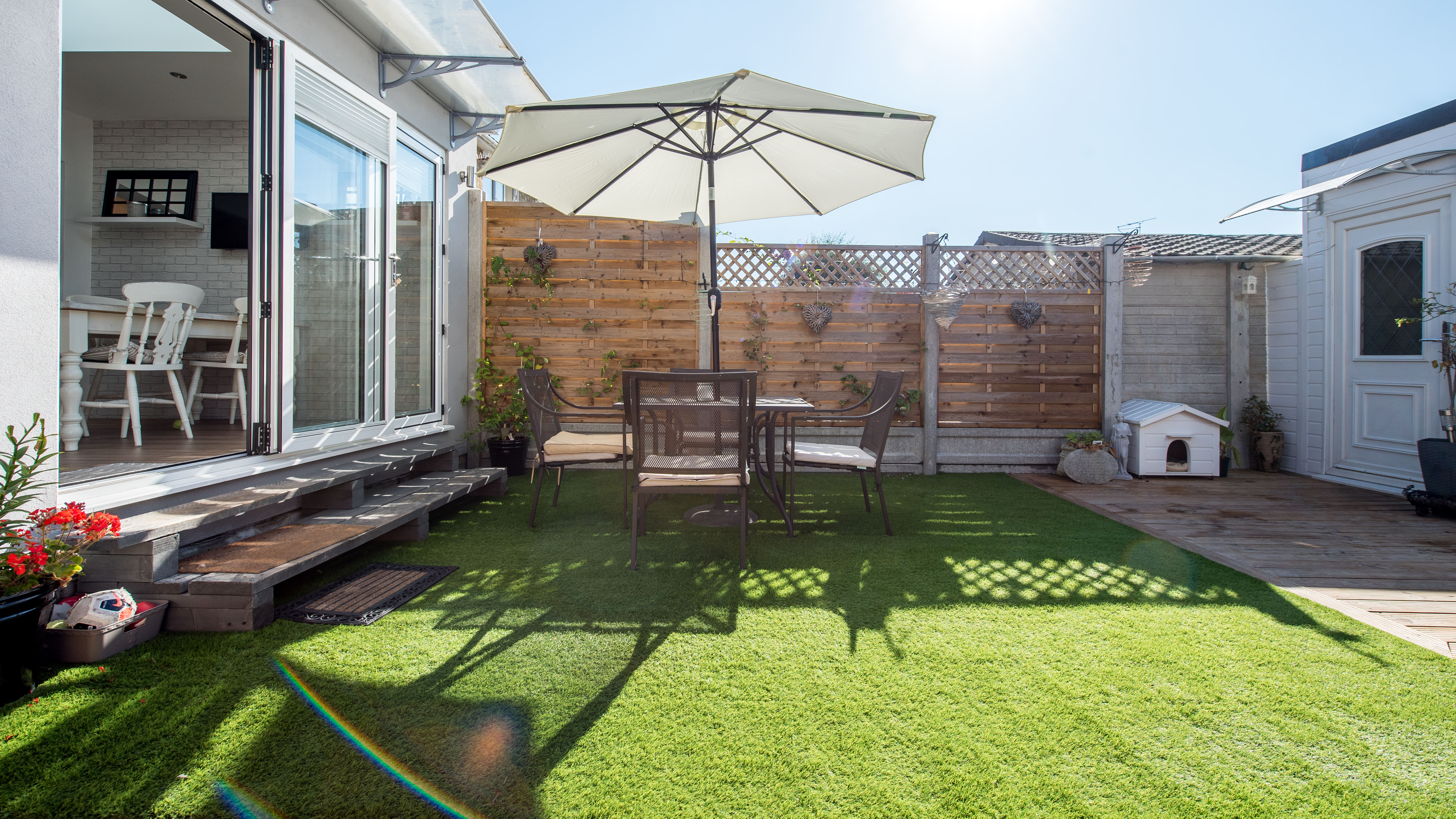 Artificial turf in a back yard with the sun shining