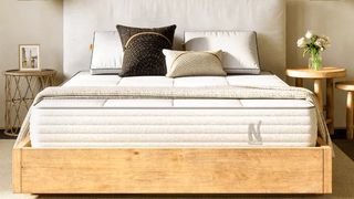 The Nolah Natural 11 Mattress on a wooden bed frame and dressed with pillows