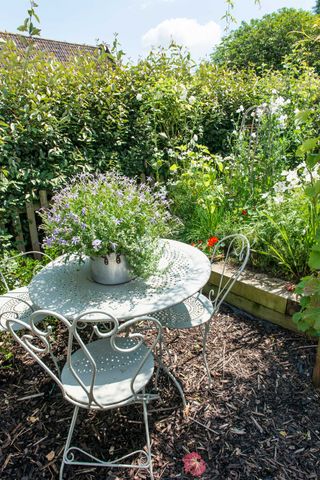 bark chippings and bistro set with potted plant