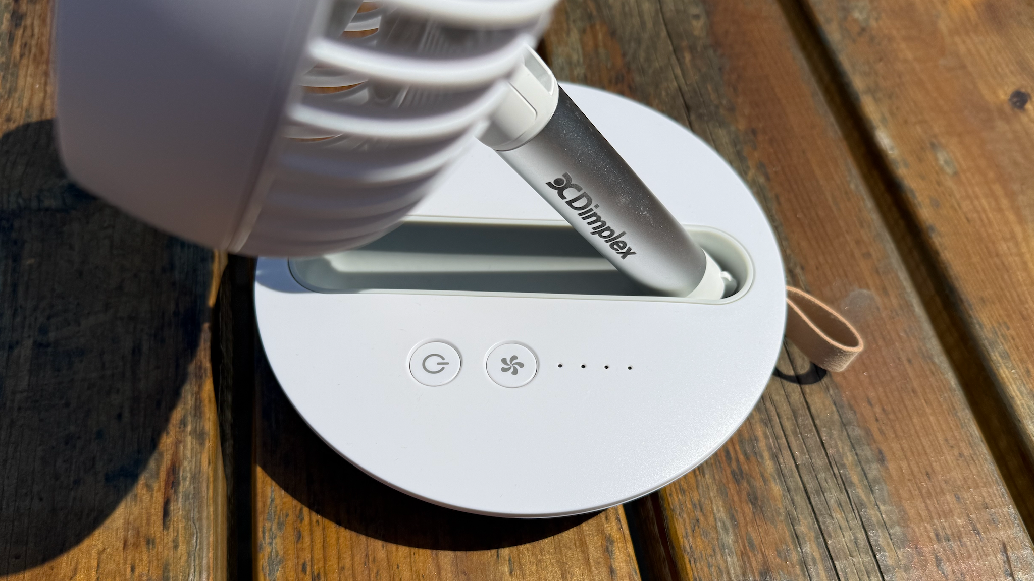 Close up of the Dimplex Rechargeable Cordless Desk Fan on a wooden bench table showing the control buttons