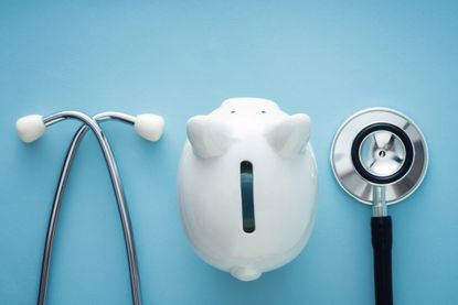 White piggy bank with stethoscope on a blue background