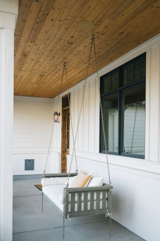 white painted front porch with swing, grey floor tiles