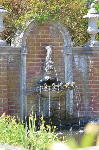 garden wall fountain with shell design