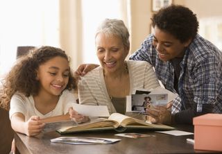 Grandmother and grandchildren looking at photographs