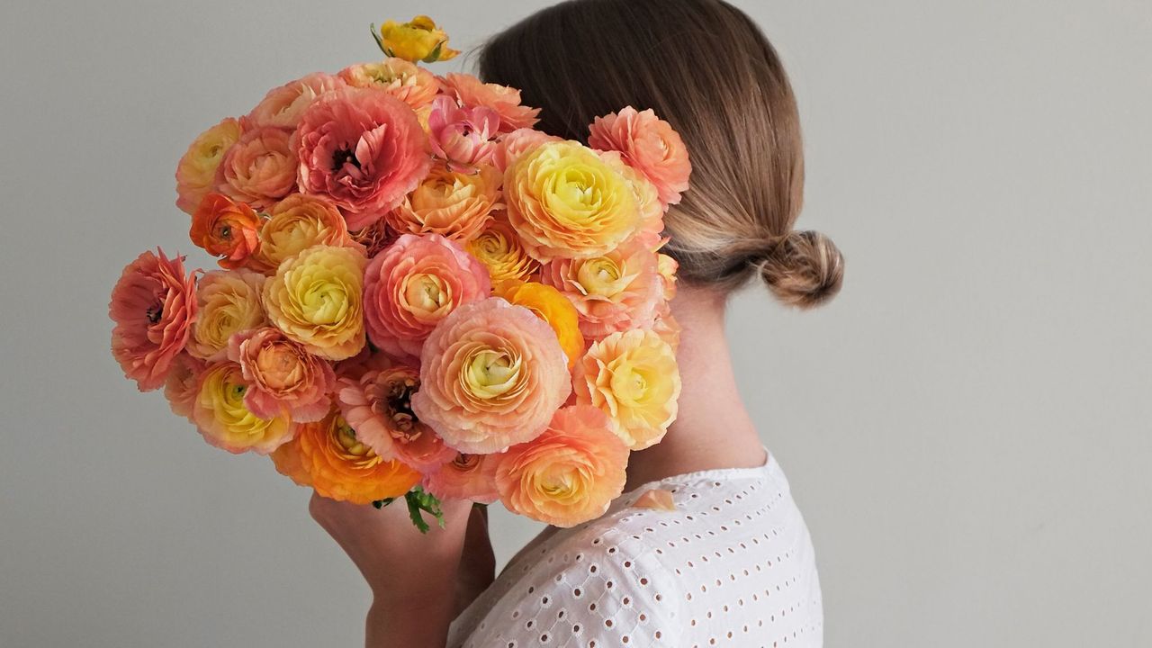 A woman holding a bunch of flowers considering the best hayfever remedies