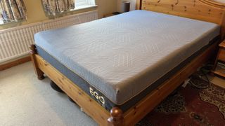 A photograph of the EGOHOME Hybrid mattress on a pine bed frame