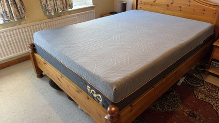 A photograph of the EGOHOME Hybrid mattress on a pine bed frame