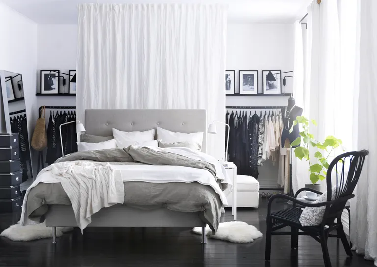 Ikea bedroom with open clothes rail and a curtain