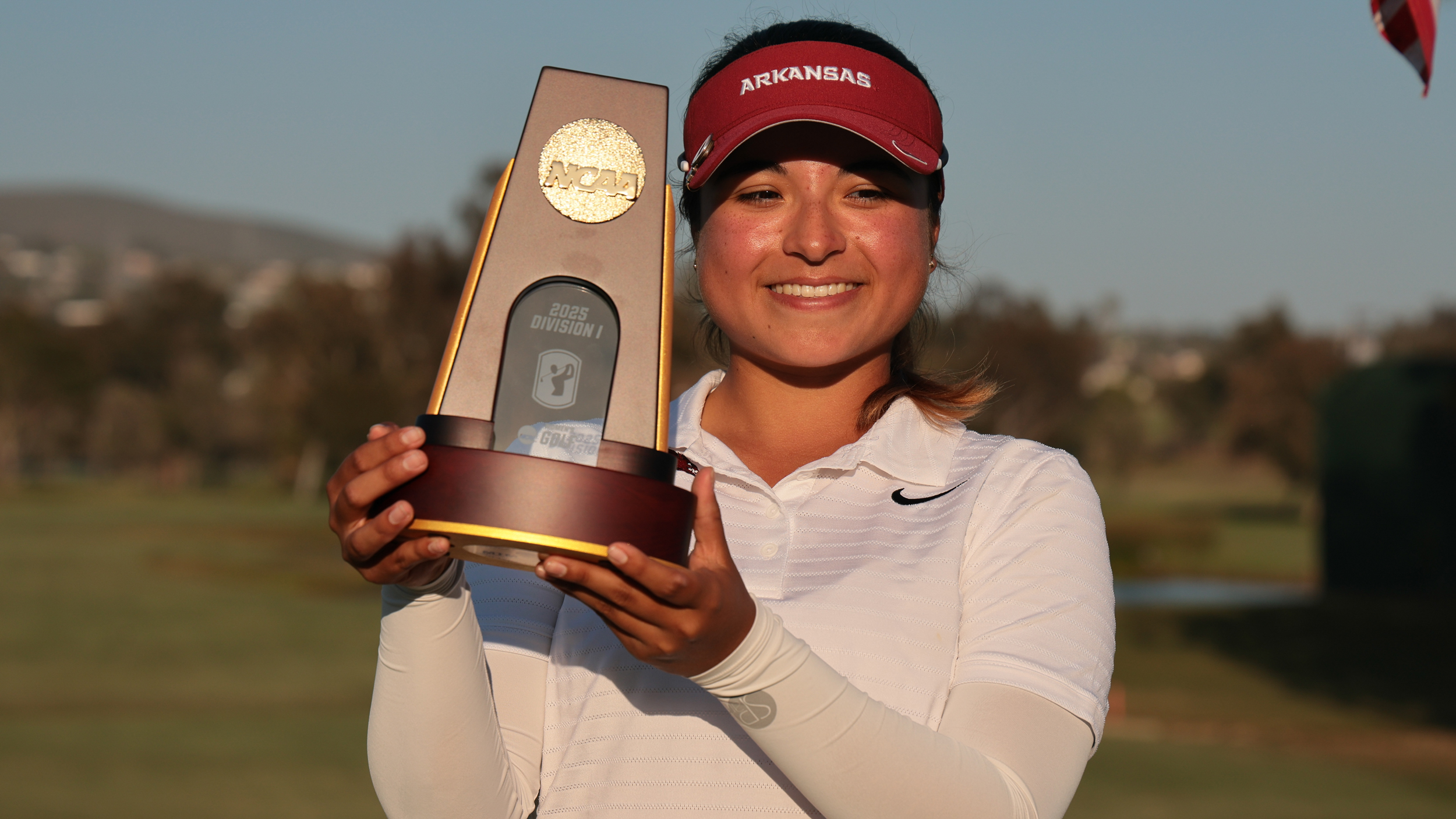 Maria Jose Marin smiles as she holds the NCAA Women's D1 Golf Championship trophy following her win in 2025
