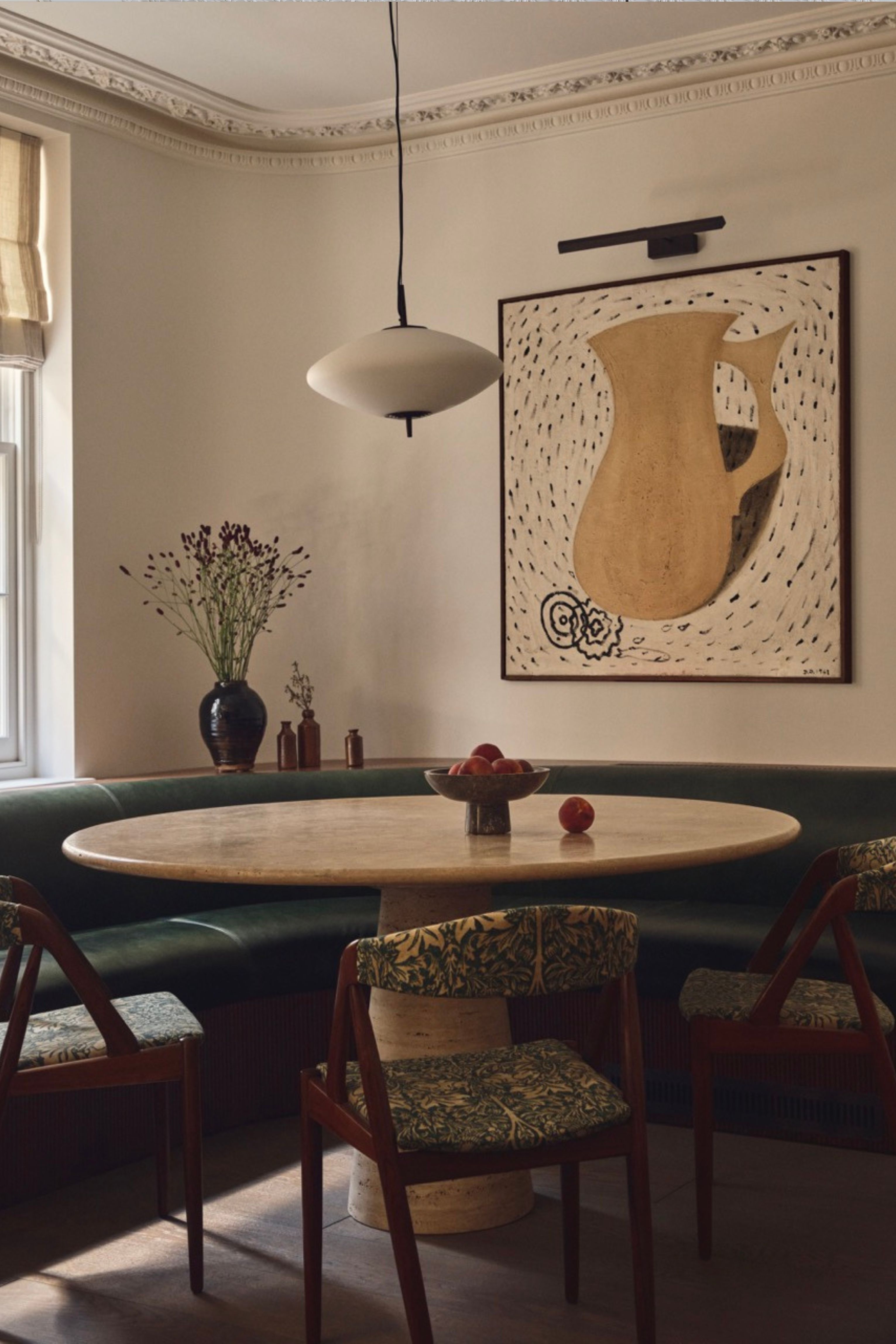a dining room with a built-in green leather banquette
