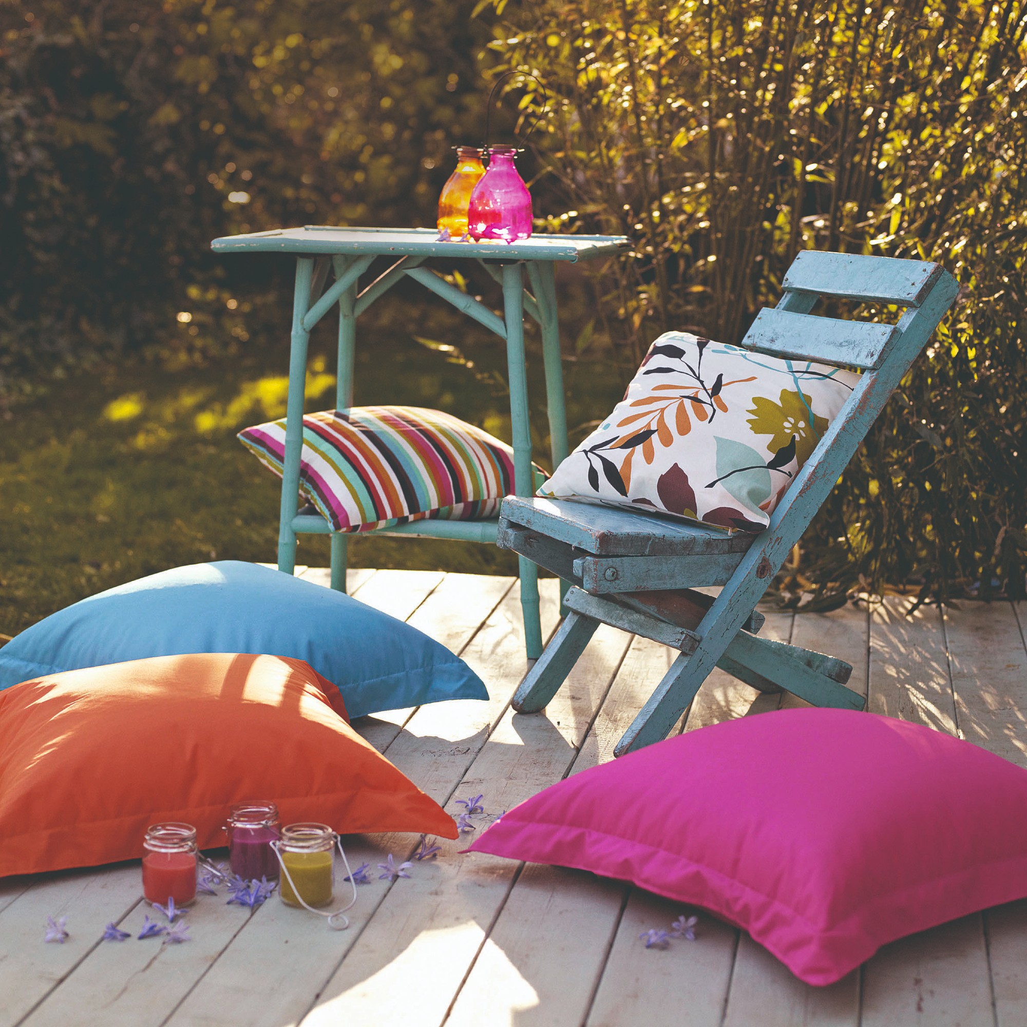 Blue garden furniture chair ready to be painted with orange, pink and blue cushions