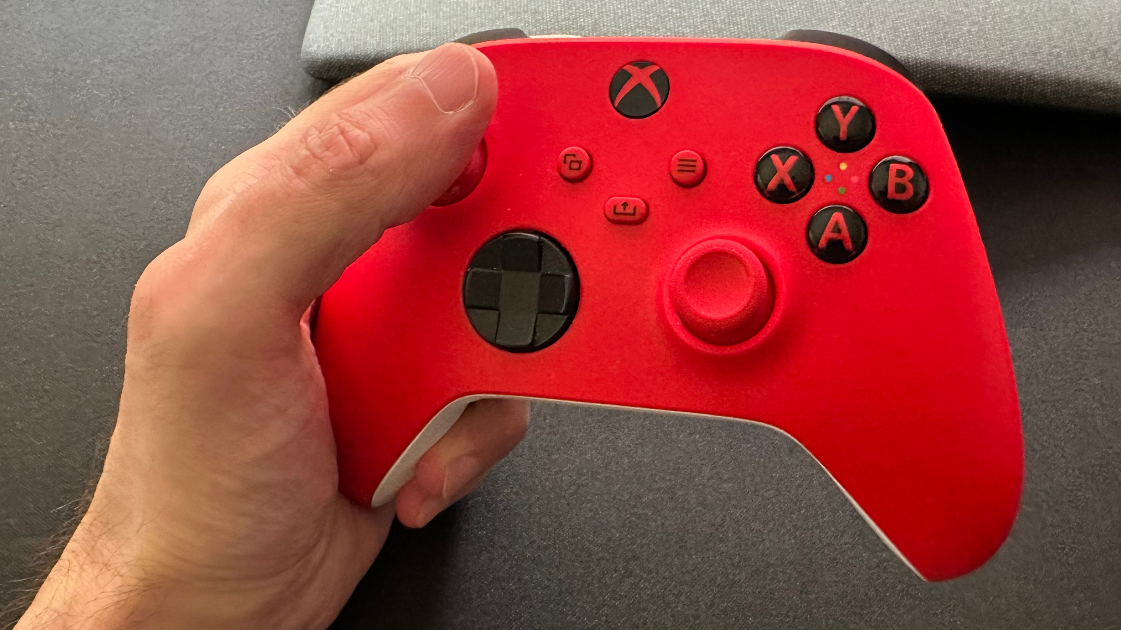 A photo of a hand holding a Microsoft Xbox game controller