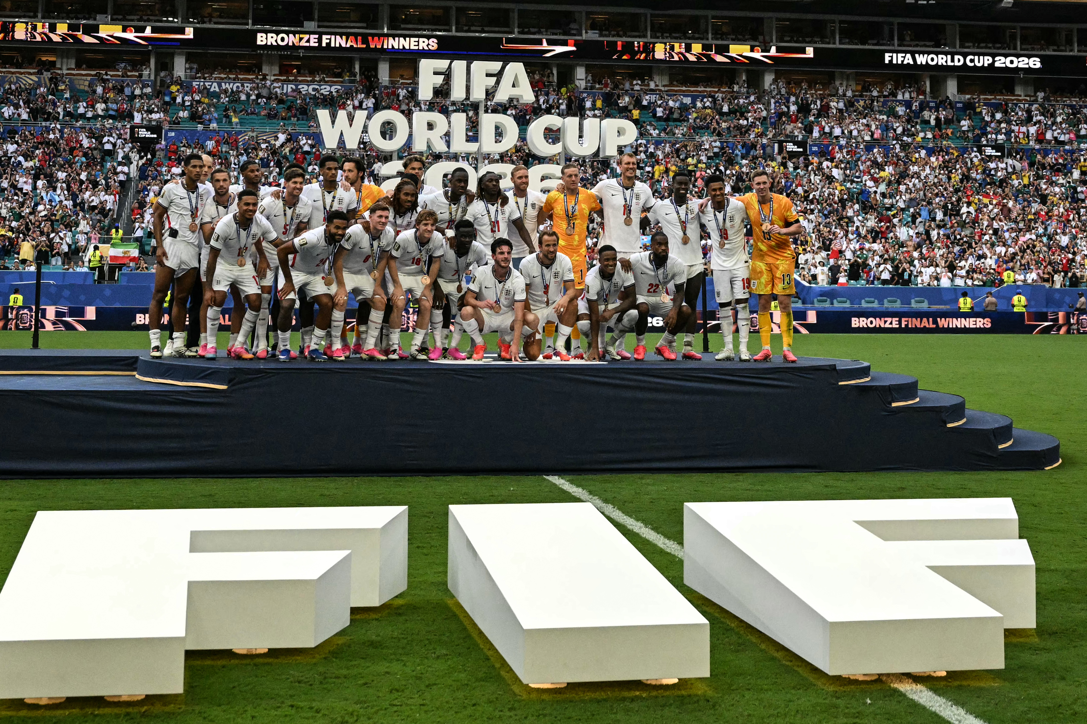 England's players pose for a photo with their medals after winning the 2026 World Cup football tournament third-place match between France and England at the Miami Stadium in Miami on July 18, 2026. (Photo by CHANDAN KHANNA / AFP)