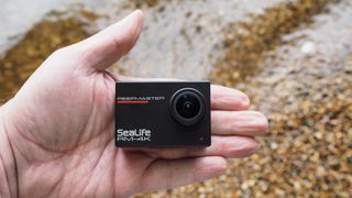 SeaLife ReefMaster RM-4K waterproof camera on a stony waterside