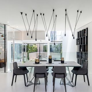 dinning room with dinning table and grey chair and overhead spider like light fitting