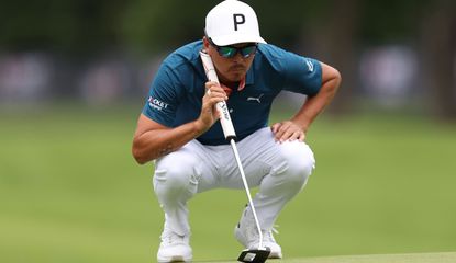 Rickie Fowler lines up a putt on the green