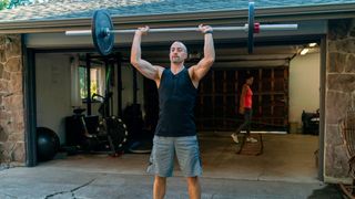 Man performs the overhead press with a barbell